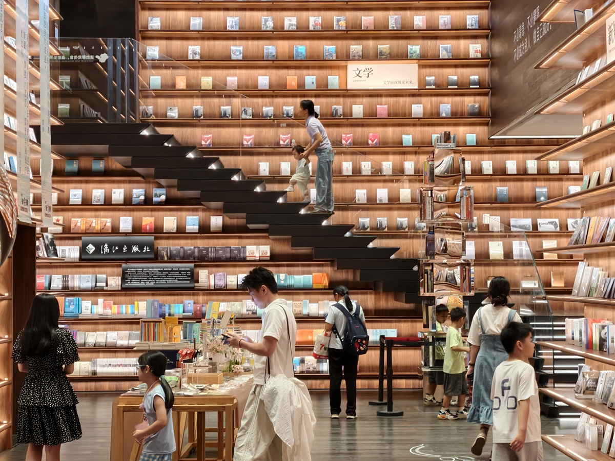 Visitors browse books at a bookstore in Nanning, South China's Guangxi Zhuang Autonomous Region, on July 13, 2026. With tall wooden book walls and floating stairs, the quiet, elegant space draws readers of all ages during summer vacation. Photo: VCG