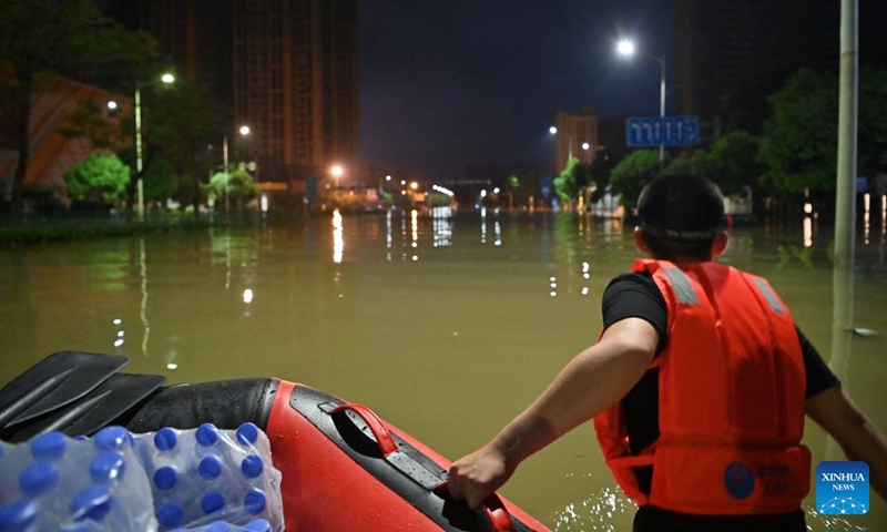 A volunteer hauls relief supplies on a waterlogged road in Guigang City, south China's Guangxi Zhuang Autonomous Region, July 9, 2026. Efforts are underway to support flood relief and recovery in Guangxi, which has been hit by severe rainstorms and flooding caused by Typhoon Maysak. (Photo: Xinhua)