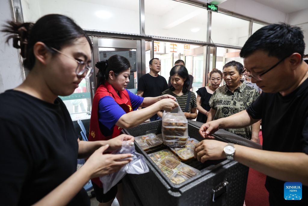 Staff members hand out lunch boxes to evacuated people at a temporary relocation in Shenyang, northeast China's Liaoning Province, July 14, 2026. Recently, heavy rainfall has caused flooding in parts of Liaoning Province. Local officials have worked on the front line to evacuate residents and provide them with temporary relocation. (Photo: Xinhua)