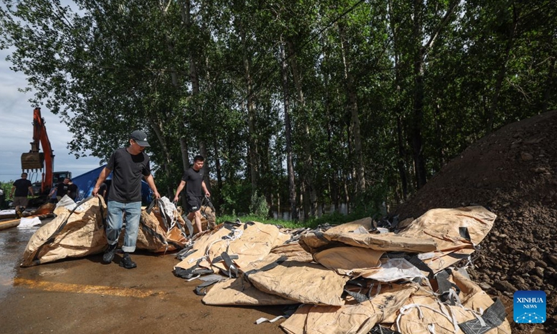 Emergency workers transfer supplies for prevention of floodwaters from overtopping a dike at Yujiatai Village of Liaozhong District, Shenyang, northeast China's Liaoning Province, July 14, 2026. Emergency responding workers in riverside towns and villages of Liaozhong District of Shenyang are working to heighten and reinforce the dikes as upstream flood discharge continues to rise the water level in the river. (Photo: Xinhua)
