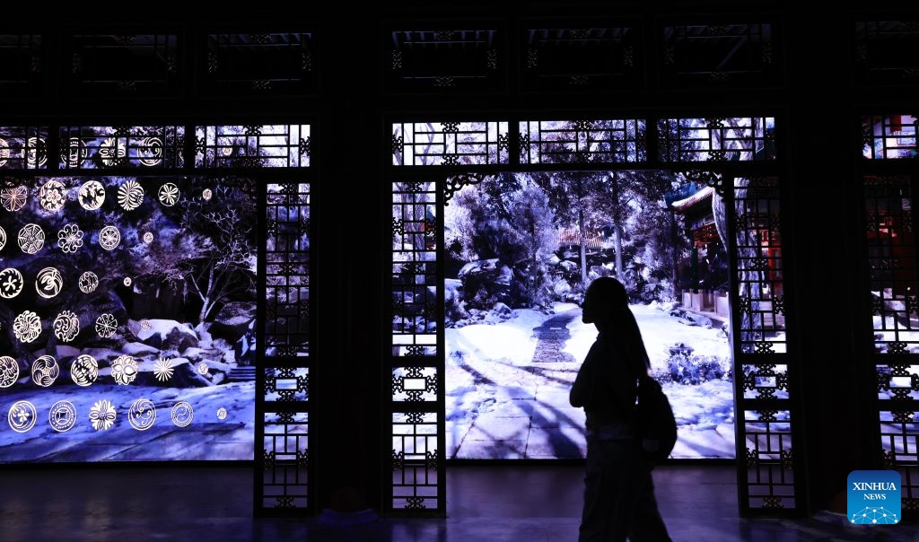 A visitor is pictured during A Garden Within: An Immersive Light and Shadow Exhibition of the Qianlong Garden at National Museum of Classic Books in Beijing, capital of China, July 14, 2026. The exhibition, which features multiple immersive scenarios and interactive installations, is held here from July 9 to Dec. 6. The Qianlong Garden, also known as the Garden of the Palace of Tranquil Longevity, was built by Emperor Qianlong (1711-1799) of Qing Dynasty (1644-1911) as a private retreat for his later years in the Forbidden City, or today's Palace Museum. (Photo: Xinhua)