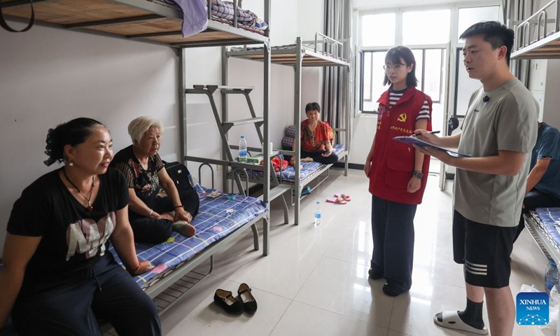 Staff members talk with evacuated people at a temporary relocation in Shenyang, northeast China's Liaoning Province, July 14, 2026. Torrential rain has caused flooding in multiple places in China recently. In rescue across the country, rescuers have risen to the occasion to protect the people. (Photo: Xinhua)