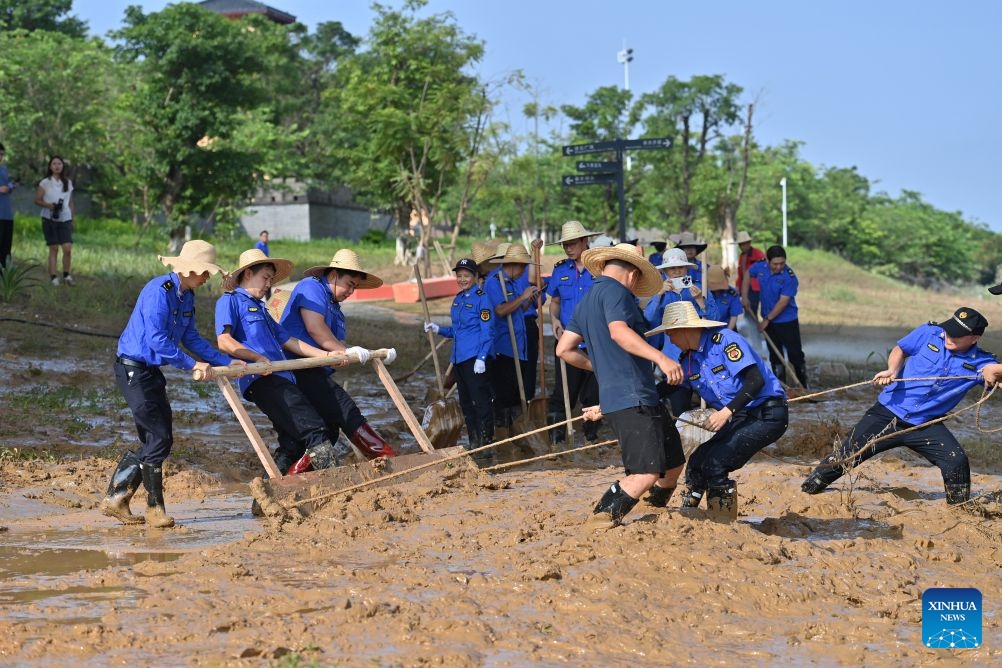 People clear mud after flooding at a park in Guigang, south China's Guangxi Zhuang Autonomous Region, July 13, 2026. (Photo: Xinhua)