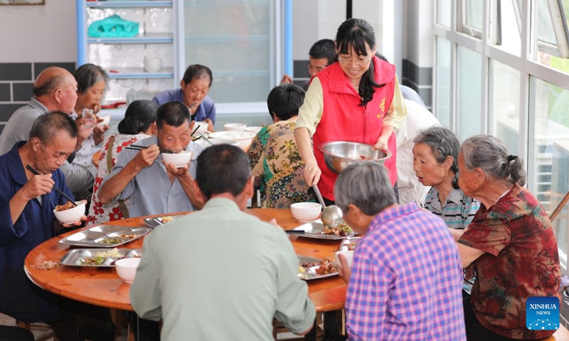 A volunteer serves lunch for relocated people at a temporary shelter in Yanggan Village of Huangshan City, east China's Anhui Province, July 12, 2026. As extreme weather has battered multiple regions across China in recent days, local authorities have implemented disaster prevention and relief measures to safeguard people's lives and property. (Photo: Xinhua)