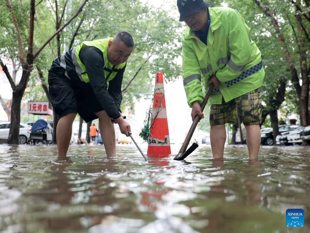 Municipal drainage staff members work on a waterlogged road in Tiexi District, Shenyang City, northeast China's Liaoning Province, July 14, 2026. Torrential rain has caused flooding in multiple places in China recently. In rescue across the country, rescuers have risen to the occasion to protect the people. (Photo: Xinhua)