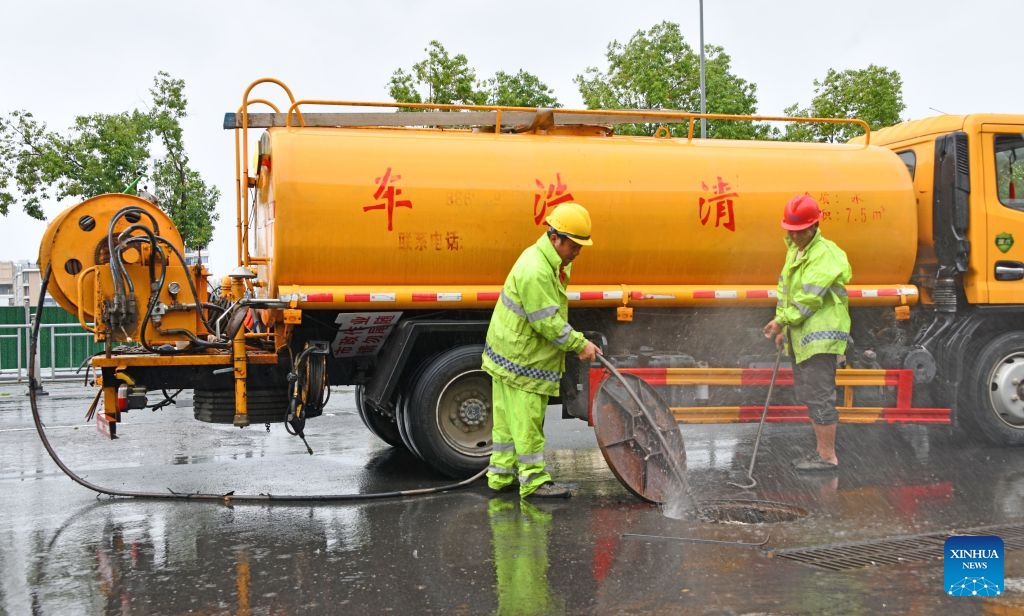 Municipal workers clean a gutter inlet in Xianju County of Taizhou City, east China's Zhejiang Province, July 11, 2026. As extreme weather has battered multiple regions across China in recent days, local authorities have implemented disaster prevention and relief measures to safeguard people's lives and property. (Photo: Xinhua)