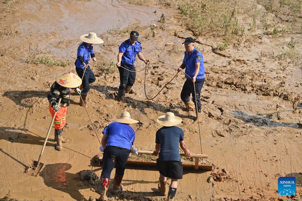 People clear mud after flooding at a park in Guigang, south China's Guangxi Zhuang Autonomous Region, July 13, 2026. (Photo: Xinhua)