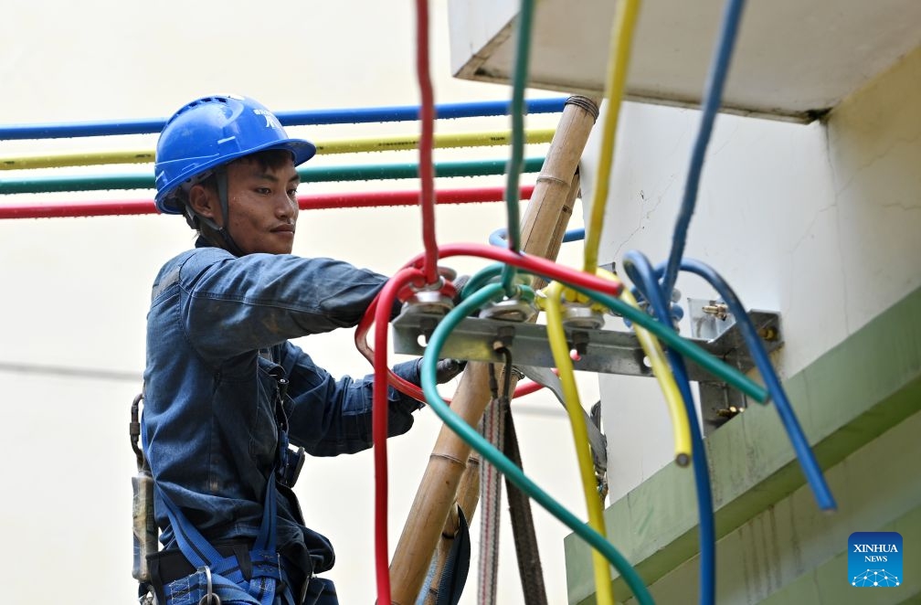 A staff member performs emergency repairing at a residential compound in Guigang City, south China's Guangxi Zhuang Autonomous Region, July 14, 2026. The power supplier in Guigang has mobilized all hands available to restore power supply as flooding inflicted by typhoon Maysak subsides in the city. (Photo: Xinhua)