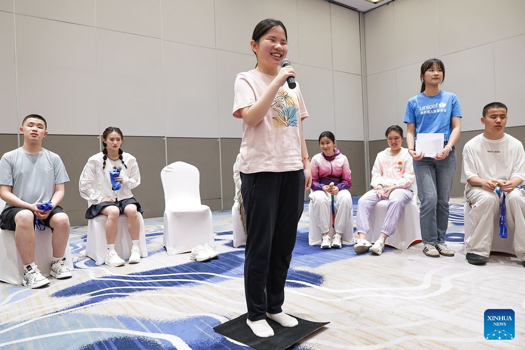 A girl tries stepping on a diving mat during a summer camp event in Beijing, capital of China, July 12, 2026. UNICEF China on Sunday invited world diving gold medalist Chen Yuxi to a summer camp event here attended by children with visual impairments, in an effort to help children with disabilities discover their potential and raise public awareness of protecting their rights. (Photo: Xinhua)