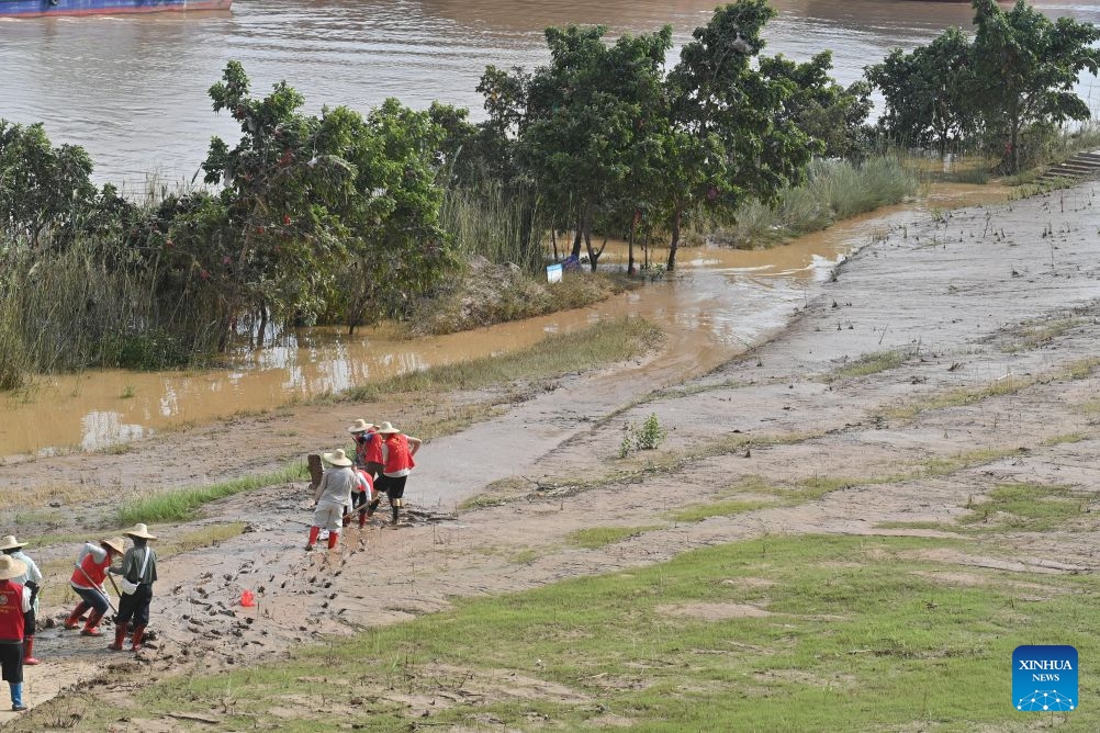 People clear mud after flooding at a park in Guigang, south China's Guangxi Zhuang Autonomous Region, July 13, 2026. (Photo: Xinhua)
