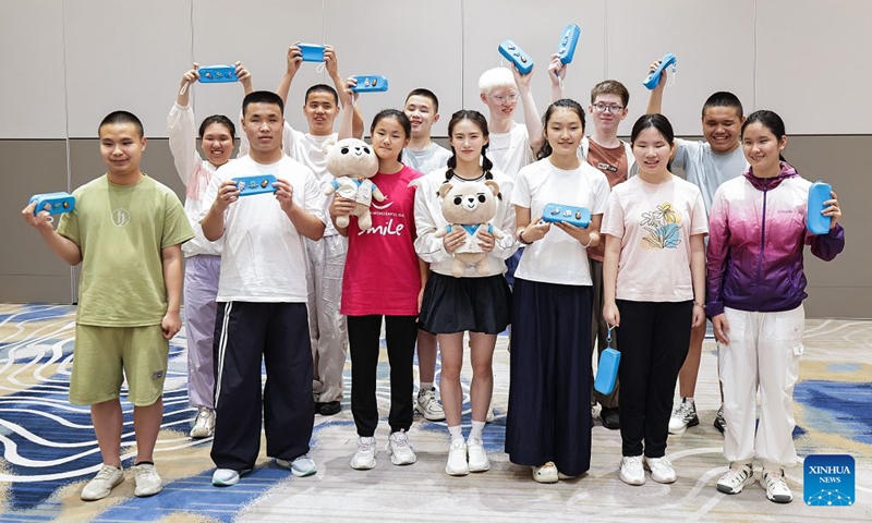 World diving gold medalist Chen Yuxi (C, front) poses for a group photo with children during a summer camp event in Beijing, capital of China, July 12, 2026. The UN Children's Fund (UNICEF) China on Sunday invited world diving gold medalist Chen Yuxi to a summer camp event here attended by children with visual impairments, in an effort to help children with disabilities discover their potential and raise public awareness of protecting their rights. (Photo: Xinhua)