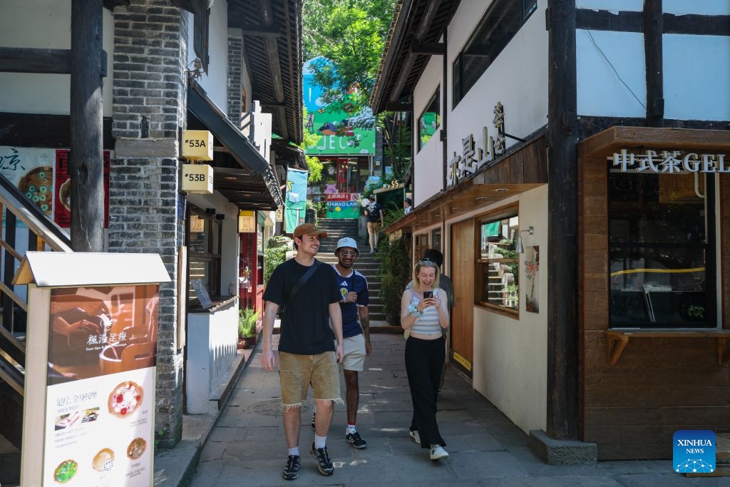Foreign tourists visit Xiahaoli Ancient Street in Nan'an District of southwest China's Chongqing Municipality, July 10, 2026. Since the beginning of this year, inbound and outbound passenger traffic at Chongqing Jiangbei International Airport has continued to grow, with a significant increase in foreign passenger traffic. In the first half of 2026, the airport handled more than 1.48 million inbound and outbound passenger trips, up 39.5 percent year on year. (Photo: Xinhua)