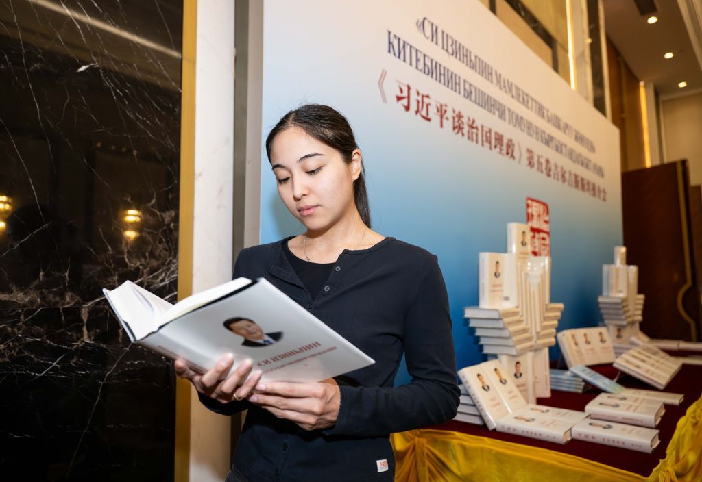 A journalist reads a copy of Xi Jinping: The Governance of China at an event promoting the fifth volume of the book, in Bishkek, the capital of Kyrgyzstan, July 13, 2026. The event was held here on Monday. (Photo: Xinhua)