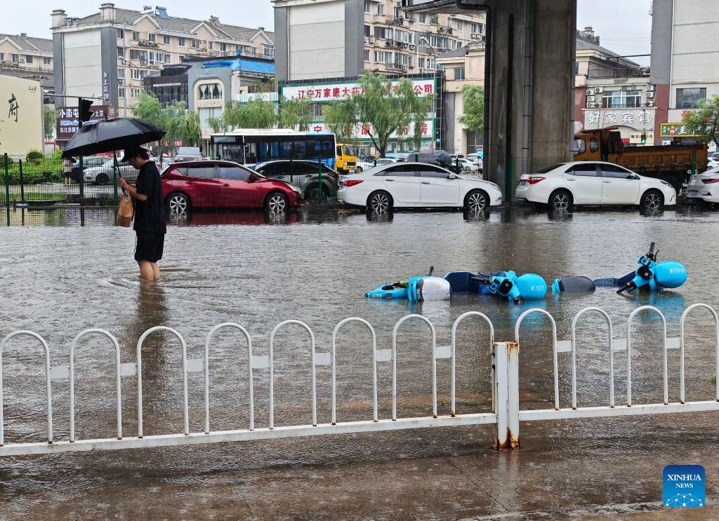 A man walks on a flooded road amid rain in Shenyang, northeast China's Liaoning Province, on July 13, 2026. From Sunday to Monday, heavy to torrential rain lashed central Liaoning Province. Several cities, including Shenyang and Fushun, suspended classes, business operations and work on Monday as a precaution, while water levels in several rivers rose significantly due to the heavy rainfall (Photo: Xinhua)