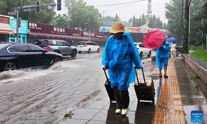 Citizens walk amid rain in Shenyang, northeast China's Liaoning Province, on July 13, 2026. From Sunday to Monday, heavy to torrential rain lashed central Liaoning Province. Several cities, including Shenyang and Fushun, suspended classes, business operations and work on Monday as a precaution, while water levels in several rivers rose significantly due to the heavy rainfall. (Photo: Xinhua)