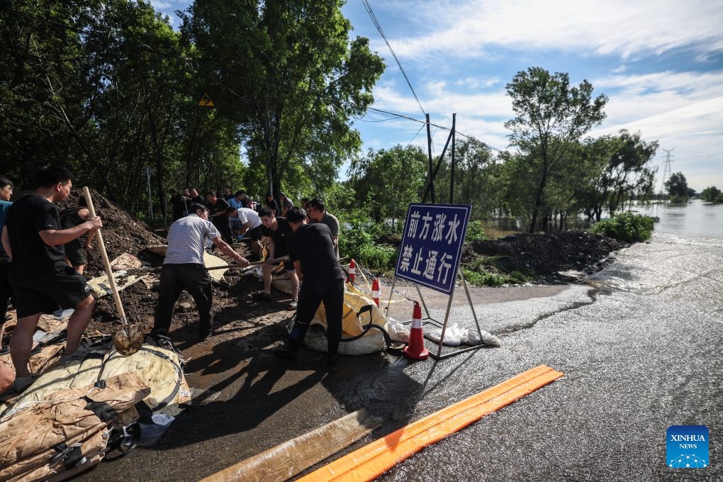 Emergency workers fill sandbags at a dike at Yujiatai Village of Liaozhong District, Shenyang, northeast China's Liaoning Province, July 14, 2026. Emergency responding workers in riverside towns and villages of Liaozhong District of Shenyang are working to heighten and fortify the dikes as upstream flood discharge continues to rise the water level in the river. (Photo: Xinhua)