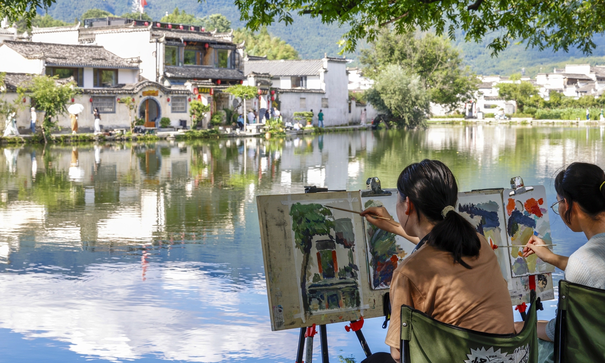 Art students sketch by a lake in Hongcun village, a UNESCO World Heritage Site, in Yixian county, East China's Anhui Province, on July 15, 2026. The architecture and carvings of the approximately 150 residences dating back to the Ming and Qing dynasties (1368-1911) are said to be among the best of their kind in China. Photo: VCG