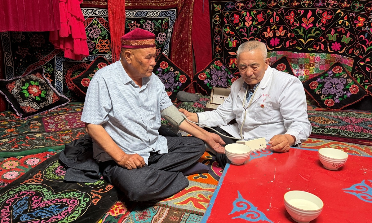 Uhas Sulayman (right) provides a herder with a free medical consultation at a summer pasture in the Barlik Mountain in Jiyek Town, Yumin County in June 2026. Photo: Chen Zishuai/GT