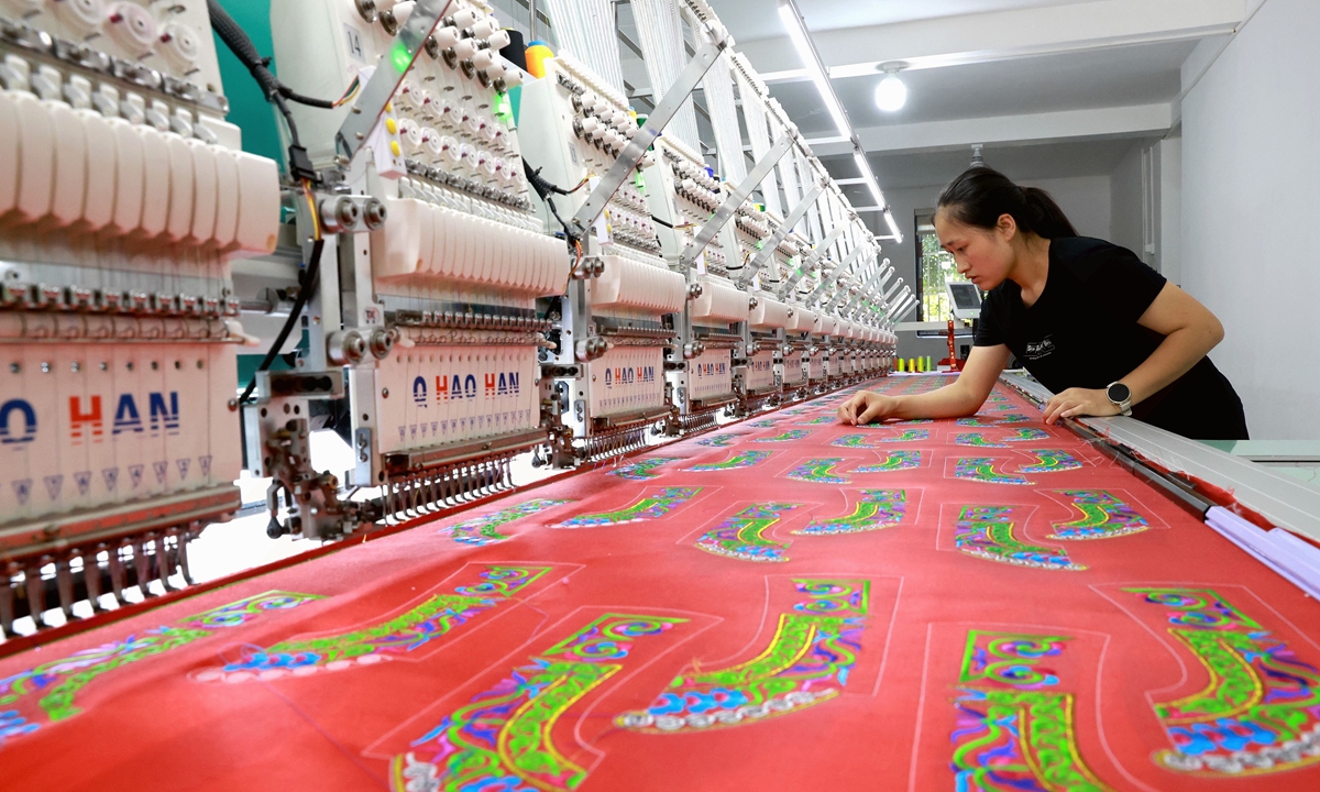 A worker operates a digital embroidery production platform inside a workshop in Rongjiang, Southwest China's Guizhou Province on July 14, 2026. By integrating ethnic embroidery with digital production, the locality has achieved large-scale manufacturing of embroidered items. This approach has helped local residents increase their income, according to media reports. Photo: VCG