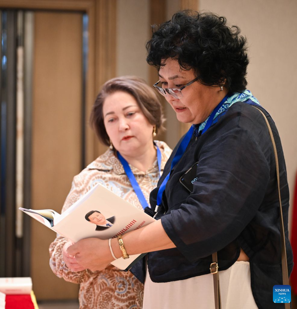Guests read a copy of Xi Jinping: The Governance of China at an event promoting the fifth volume of the book in Astana, Kazakhstan, July 15, 2026. The event was held here on Wednesday. (Xinhua/Li Renzi)