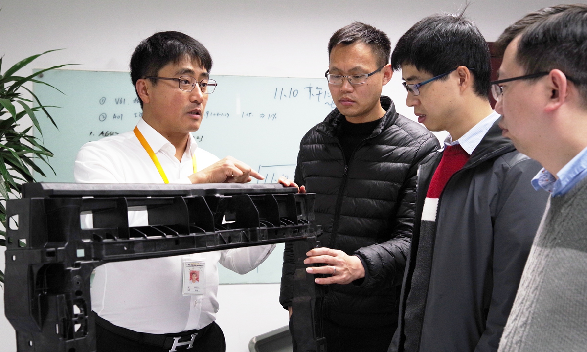 Engineer Sun Gang (left) and his team members discuss technical solutions in the laboratory. Photo: Courtesy of Sun Gang