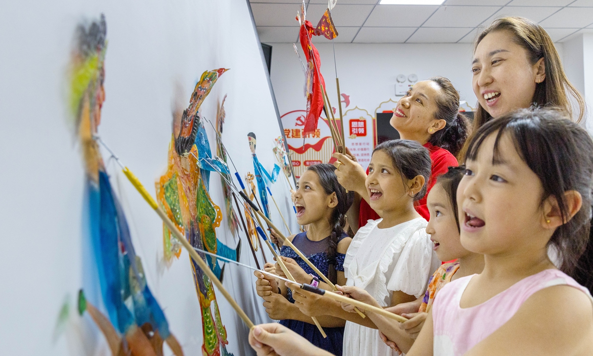 Children try their hand at traditional Chinese shadow puppetry during a cultural activity at Yangmaohu community in Tianshan district of Urumqi, Northwest China's Xinjiang Uygur Autonomous Region on July 15, 2026. Photo: VCG