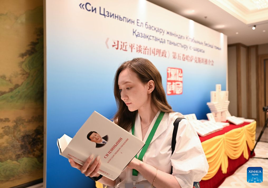 A journalist reads a copy of Xi Jinping: The Governance of China at an event promoting the fifth volume of the book in Astana, Kazakhstan, July 15, 2026. The event was held here on Wednesday. (Xinhua/Li Renzi)