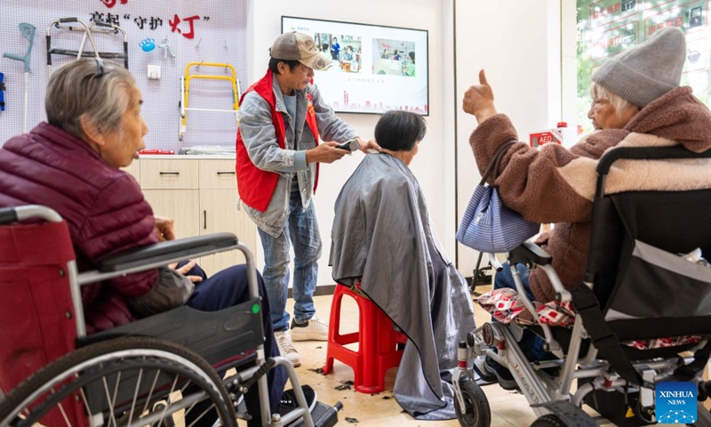 A volunteer (2nd L) cuts hair for elders for free at a residential compound in Wangcheng District of Changsha, central China's Hunan Province, Nov. 6, 2025. During China's 14th Five-Year Plan period (2021-2025), over 240,000 old urban residential compounds were renovated across the country, benefiting more than 40 million households and 110 million residents. Under urban renewal initiatives, 129,000 elevators have been installed, over 3.4 million parking spaces have been added, and 64,000 residential compound service facilities providing services such as senior and child care have been constructed. (Photo: Xinhua)