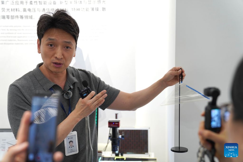 Jin Chengjiu, director of the Specialty Polymers Research Center under the Yongjiang Laboratory (Y-LAB), introduces research achievements in Ningbo, east China's Zhejiang Province, July 27, 2026. Focusing on new materials and related areas, the Yongjiang Laboratory (Y-LAB), launched by Zhejiang Province and Ningbo City, is committed to delivering cutting-edge basic research and leveraging technological innovations to support economic development. (Photo by Liu Zhihan/Xinhua)

