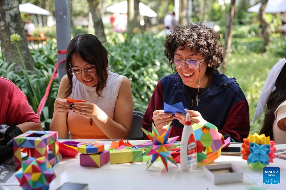 People take part in an origami workshop at the San Angel Flower Fair in Mexico City, Mexico, July 14, 2026. The annual event features flower markets, handicraft displays and cultural performances, highlighting local horticulture traditions, folk art and the historic charm of the district. (Photo: Xinhua)