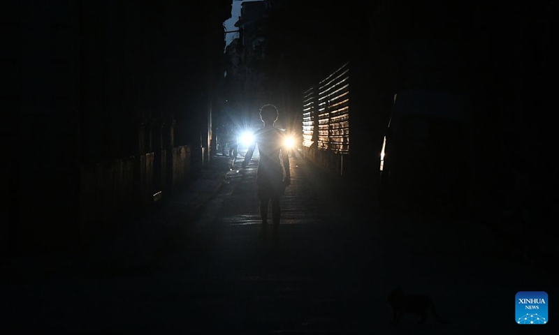 A citizen walks along a street at night during a nationwide blackout in Havana, capital of Cuba, July 14, 2026. Cuba was hit by a third nationwide blackout in a little over a week on Tuesday, the National Electric Union said. (Photo: Xinhua)