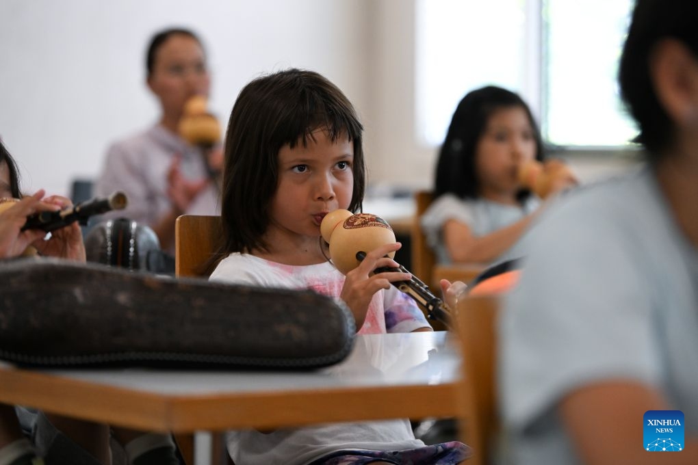 A child learns to play the Hulusi, a traditional Chinese wind instrument, during a Chinese culture summer camp in Bern, Switzerland, July 14, 2026. A summer camp featuring traditional Chinese culture opened here on Tuesday. (Photo: Xinhua)