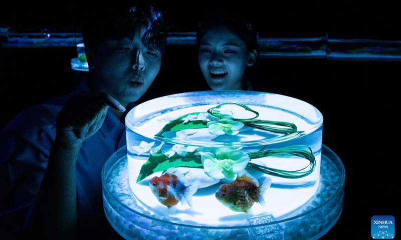 People view fishes in illuminated tanks during an art exhibition at the Lotte World Aquarium in Seoul, South Korea, July 15, 2026. (Photo: Xinhua)