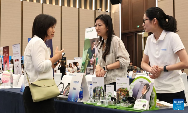 An exhibitor talks with staff members during the 9th China International Import Expo (CIIE) Promotion and Roadshow at the National Exhibition and Convention Center (Shanghai), the main venue for the ninth CIIE, in east China's Shanghai, on July 27, 2026. 