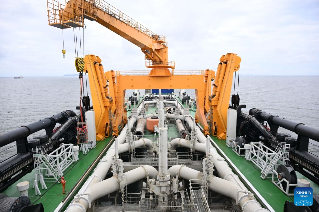 Staff members work on the deck of the Junguang dredger on July 14, 2026. The Junguang, a mega dredger with a 35,000 cubic meter capacity, was recently put into operation. Measuring 198 meters in length, with a maximum dredging depth of 120 meters and a deadweight of 60,483 tonnes, the vessel is the largest of its kind in Asia. (Photo: Xinhua)