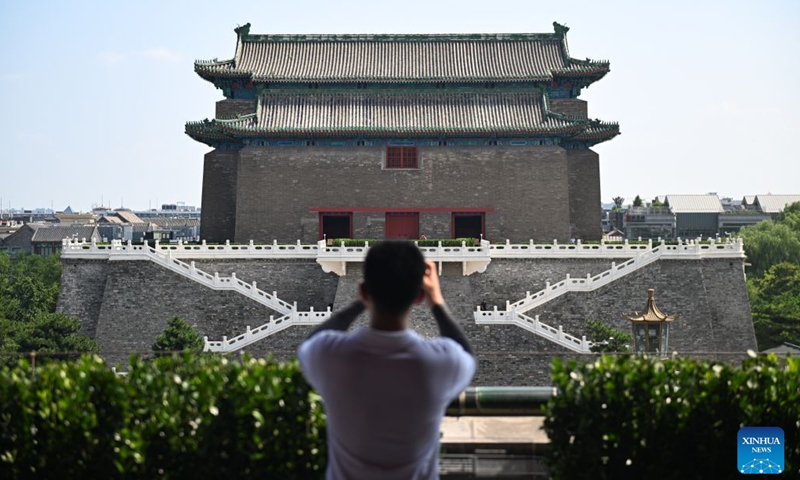 A visitor takes photos of the Zhengyangmen Archery Tower on the Zhengyangmen Gate in Beijing, capital of China, July 27, 2026. 