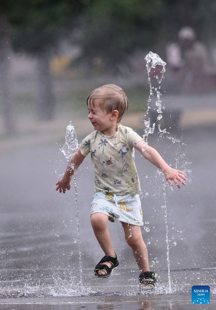 A boy cools off at a splash pad during a heatwave in Vienna, Austria, July 15, 2026. (Photo: Xinhua)