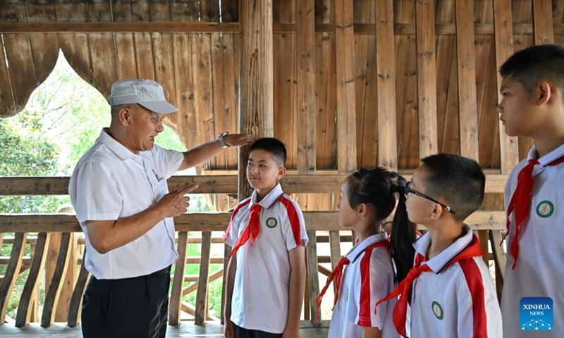 A docent briefs primary students on a 1.5-meter mark in Zhongfu Village of Changting County, southeast China's Fujian Province, July 24, 2026. The mark was used to measure the height of Red Army recruits.