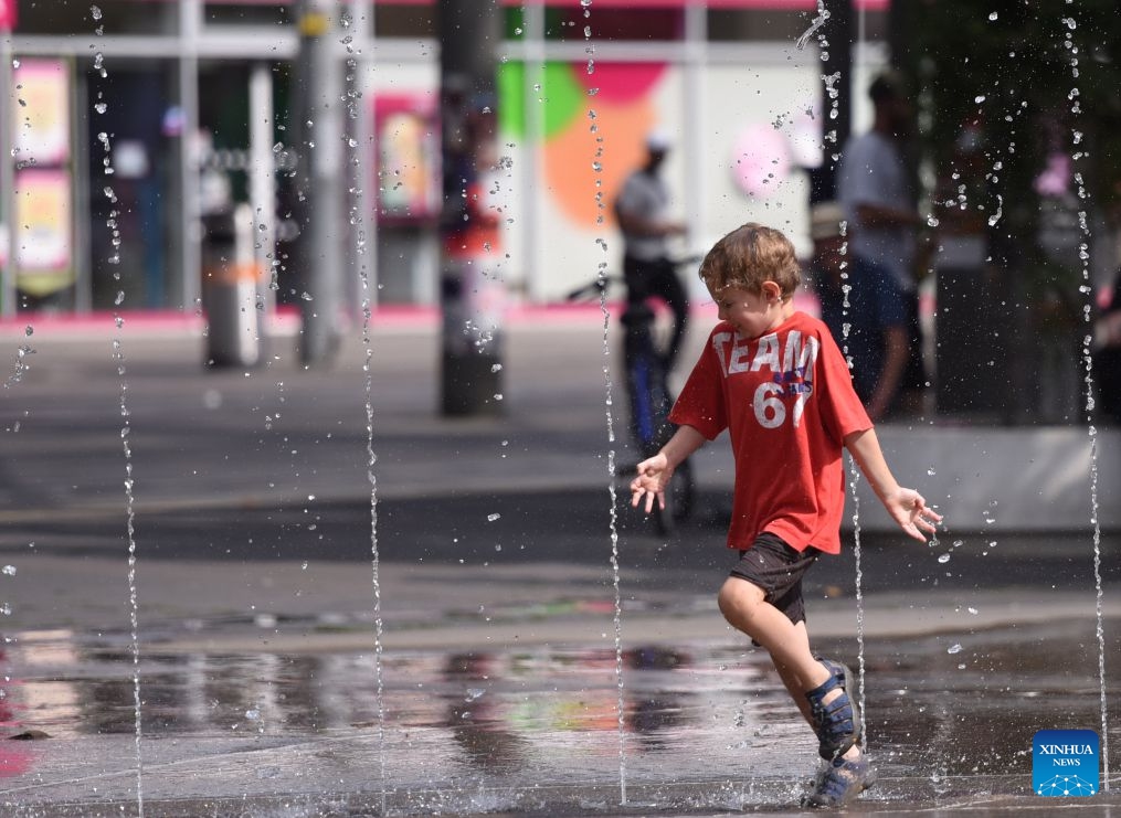 A boy cools off at a splash pad during a heatwave in Vienna, Austria, July 15, 2026. (Photo: Xinhua)