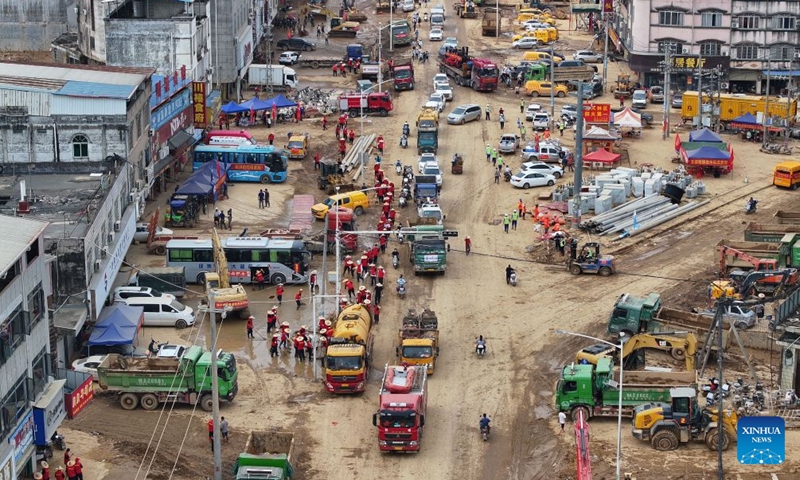 An aerial drone photo taken on July 14, 2026 shows people clearing a street in Yunbiao Town of Hengzhou City, Nanning City of south China's Guangxi Zhuang Autonomous Region. Efforts are underway to facilitate flood relief and recovery in Guangxi, which has been hit by severe rainstorms and flooding caused by Typhoon Maysak. (Photo: Xinhua)