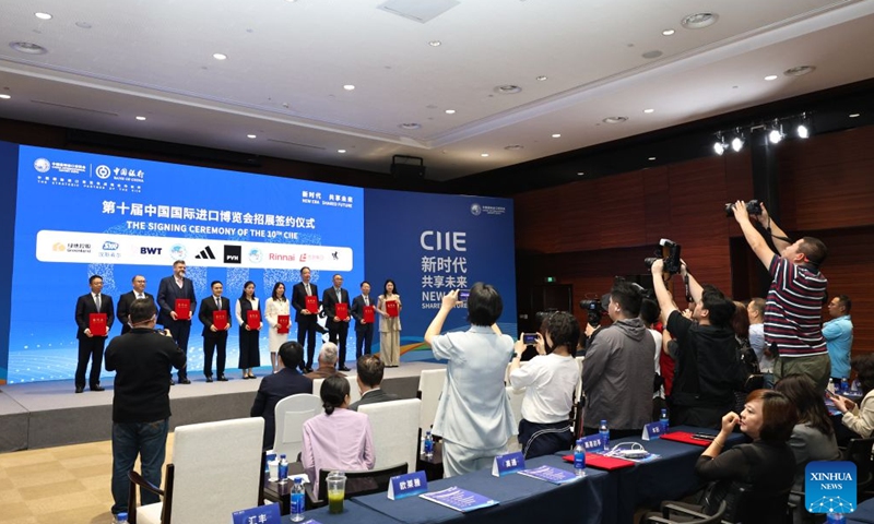 People pose for a photo during the signing ceremony of the 10th China International Import Expo (CIIE) at the National Exhibition and Convention Center (Shanghai), the main venue for the ninth CIIE, in east China's Shanghai, on July 27, 2026.