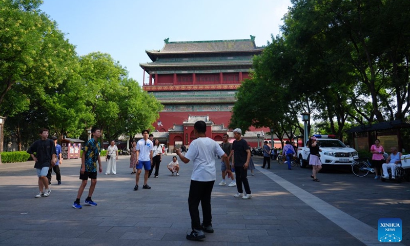 People kick a shuttlecock at a square connecting the Drum and Bell Towers in Beijing, capital of China, July 27, 2026. 