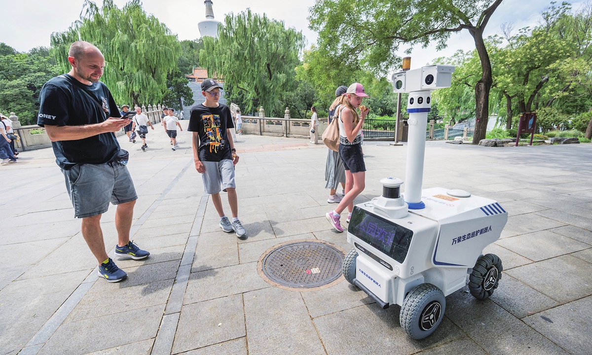 Tourists encounter an ecological patrol robot on duty at Beihai Park in Beijing on July 16, 2026. The robot is capable of detecting uncivilized behavior, identifying facility malfunctions, monitoring the status of trash bins, and interacting with visitors. Photo: Chen Tao/GT