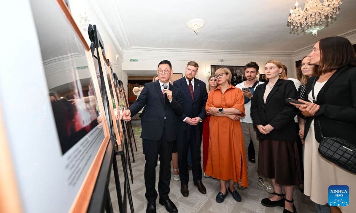 Chinese Consul General in Yekaterinburg Luo Shixiong (1st L, front) briefs Anton Artemov (2nd L, front), deputy governor of the Chelyabinsk region, Irina Anfalova-Shishkina (3rd L, front), first deputy minister of culture of the Chelyabinsk region and other guests on photos displayed at a photo exhibition showcasing the achievements of Chinese modernization in Chelyabinsk, Russia, July 15, 2026. A photo exhibition showcasing the achievements of Chinese modernization opened Wednesday in Russia's central city of Chelyabinsk, attracting more than 100 participants from political, media and business circles, as well as youth representatives from China and Russia.(Xinhua/Feng Kaihua)