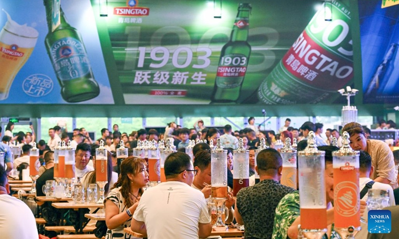 Customers drink beer at a beer tent at Xihai'an (West Coast) New Area in Qingdao, east China's Shandong Province, on July 17, 2026. The 36th Qingdao International Beer Festival opened on Friday evening in the coastal city of Qingdao, east China's Shandong Province, kicking off a 30-day celebration that blends brewing tradition with tech advances and cultural performances. Running until Aug. 15, the festival boasts nine beer tents offering more than 2,300 varieties from around the world, including premium craft brews and fruit-flavored beers. (Photo: Xinhu)