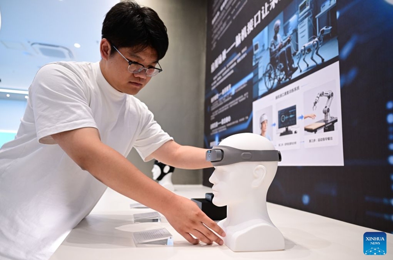 A staff member demonstrates a brain health monitoring headband at the exhibition hall of China Sensor Valley in Bengbu, east China's Anhui Province, July 17, 2026. Bengbu, a traditional industrial city, has stepped up the development of its brain-computer interface (BCI) industry in recent years. By strengthening collaboration among industry, research institutes and medical institutions, Bengbu has built an innovation ecosystem that supports both BCI research and clinical application, aiming to become an emerging BCI innovation hub in the Yangtze River Delta region. Photo: Xinhua