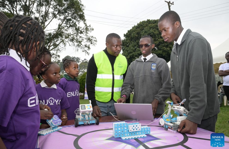 Students (1st R and 2nd R) adjust a robot during an artificial intelligence (AI)-enabled coding and robotics competition in Kiambu county, central Kenya, July 17, 2026. More than 200 young learners participated in the competition here on Friday.(Xinhua/Yang Guang)