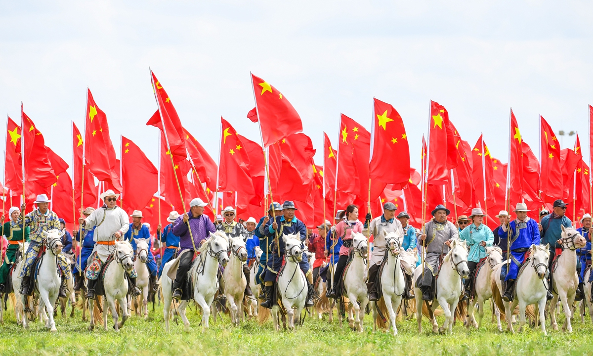 Performers wave Chinese national flags while dressed in vibrant traditional ethnic attire at the opening ceremony of the 36th Naadam Festival in Xilin Gol League, North China's Inner Mongolia Autonomous Region, on July 18, 2026. Photo: VCG