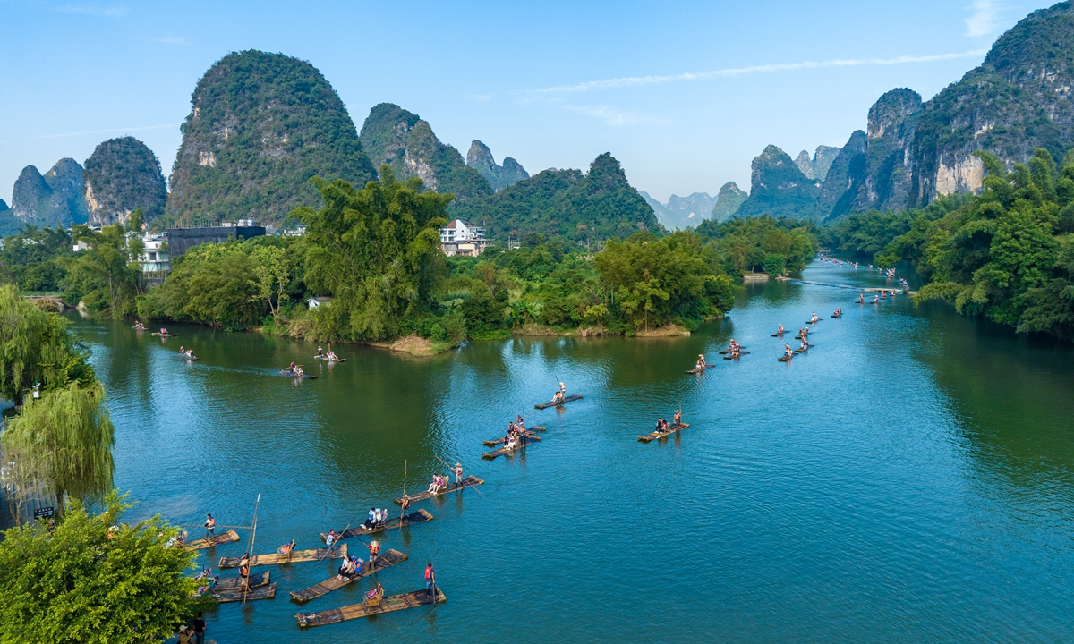 Tourists enjoy a cool respite from the summer heat aboard bamboo rafts at the Yulong River Scenic Area in Yangshuo county, Guilin, South China's Guangxi Zhuang Autonomous Region on July 19, 2026. With the start of summer vacation, Yangshuo has entered its peak tourism season, with all local scenic spots seeing a strong surge in visitor arrivals. Photo: VCG