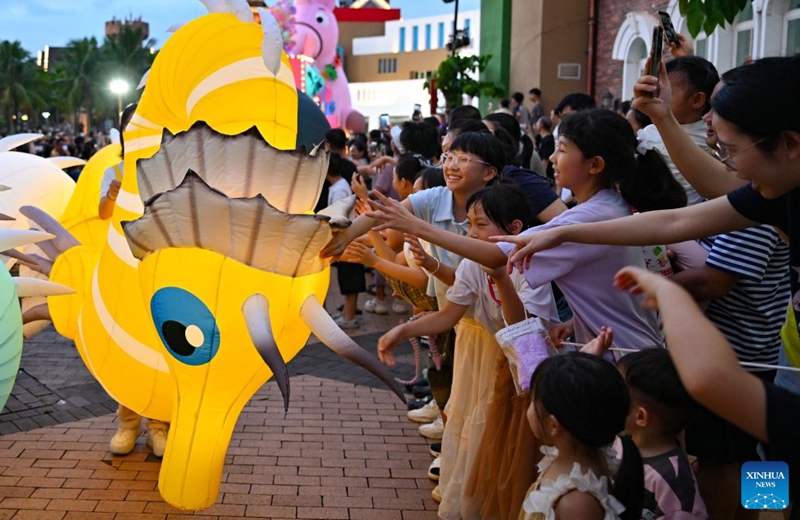 A performer interacts with audiences during a carnival parade in Haikou, south China's Hainan Province, July 18, 2026. The 2026 Hainan Island Carnival opened here on Saturday and will last until Aug. 18, during which over 50 special events will be held. (Xinhua/Guo Cheng)